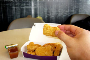 A chicken McNugget being held in someone's hand
